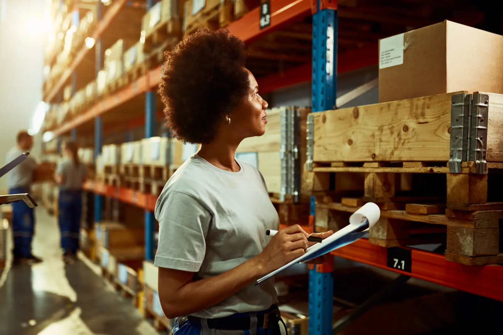 Logistics worker writing inventory list checking stock in warehouse room
